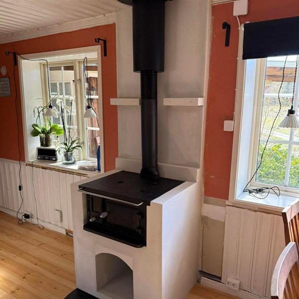 Svart köksspis installerad i ett ljust kök